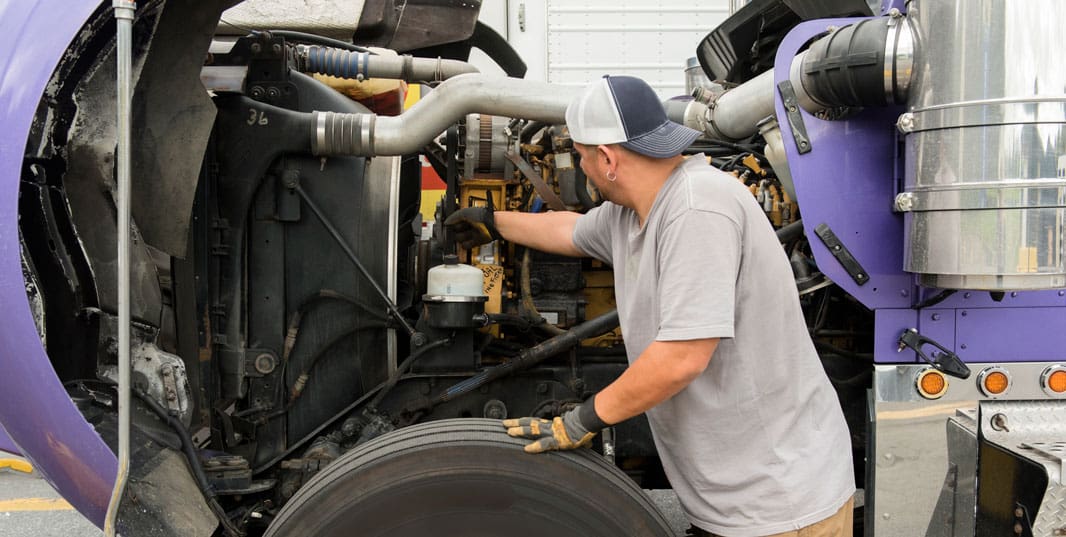 Truck driver cleaning semi-truck.