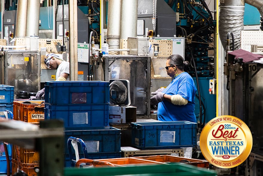 Image of two employees working on a factory floor surrounded by pipes and boxes. The Best of East Texas Winner 2025 logo is overlayed in the bottom right corner.